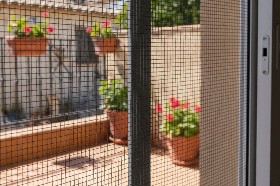Mosquitera corredera con malla de fibra de vidrio en una puerta de balcón en Sabadell
